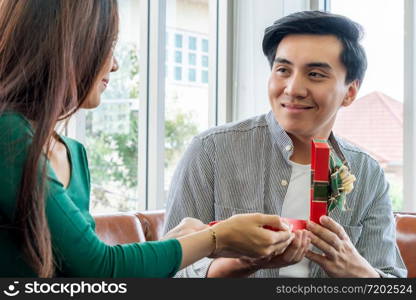 Happy couple giving gift present to celebrate anniversary. Marriage lifestyle, love and relationship concept.