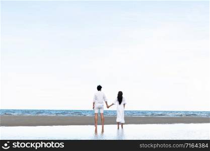Happy couple going honeymoon travel on tropical sand beach in summer.. Couple going honeymoon on tropical beach in summer