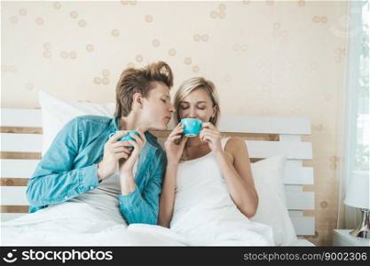 Happy couple hand holding cup and drinking coffee in the morning