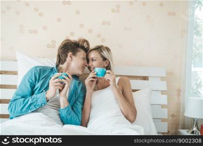 Happy couple hand holding cup and drinking coffee in the morning