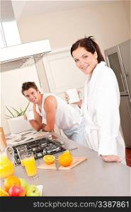Happy couple having breakfast in the kitchen, drinking coffee