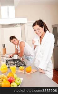 Happy couple having breakfast in the kitchen, drinking coffee