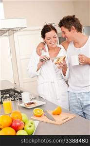 Happy couple having breakfast in the kitchen woman preparing food
