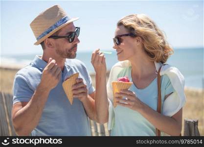 happy couple having date and eating ice cream on vacation