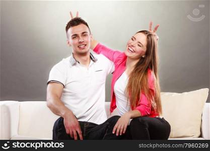 Happy couple having fun and fooling around.. Happy couple having fun and fooling around. Joyful man and woman have nice time using fingers as bunny ears. Good relationship.