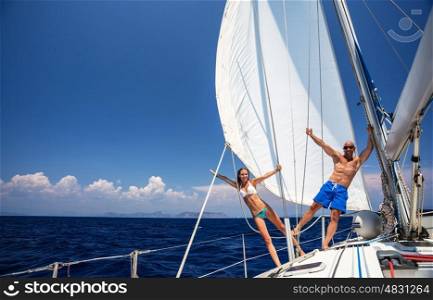 Happy couple having fun on sailboat, young family in water cruise, yachting sport, active lifestyle, summer vacation, romantic trip, travel and tourism concept&#xA;