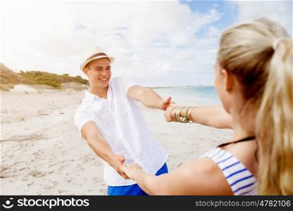 Happy couple having fun on the beach.. Happy young couple having fun on the beach.