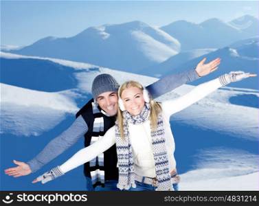 Happy couple having fun, raised arms flying hands, outdoors at winter snowy mountains, people at nature, blue wintertime landscape background, Christmas vacation holidays, love concept