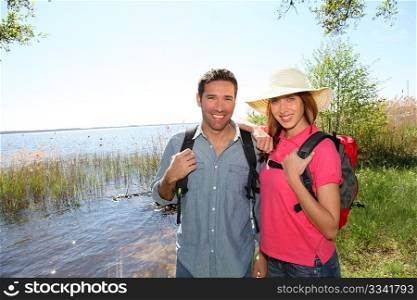 Happy couple hiking by a lake