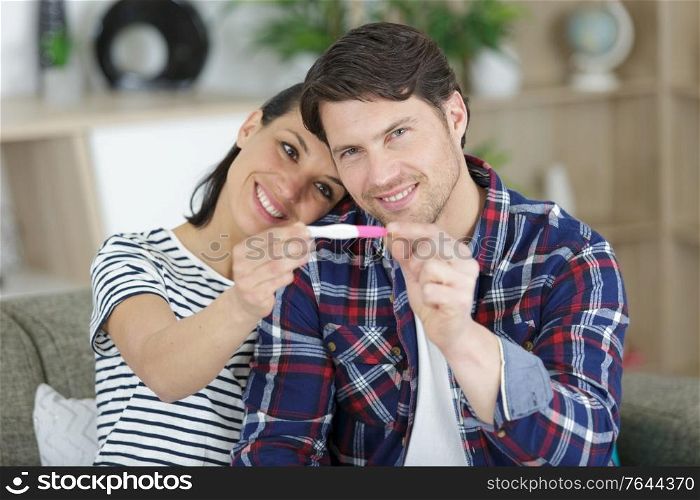 happy couple holding pregnancy test