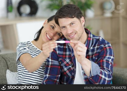 happy couple holding pregnancy test