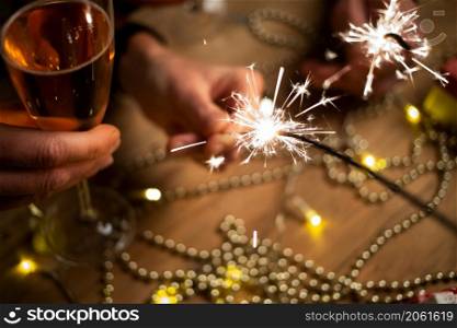 happy couple holding sparkles and champagne glasses New Year party