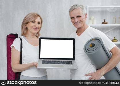 happy couple holding yoga mat laptop with white screen home