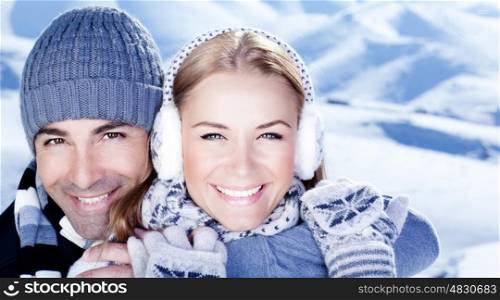 Happy couple hugs, holding hands, close up face portrait, outdoor at winter snowy mountains, people over natural blue wintertime landscape background, Christmas vacation holidays, love concept