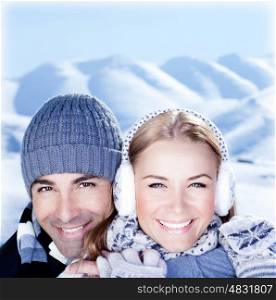 Happy couple hugs, holding hands, close up face portrait, outdoor at winter snowy mountains, people over natural blue wintertime landscape background, Christmas vacation holidays, love concept