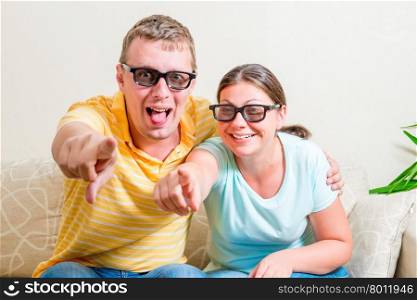 happy couple in 3D glasses watching television at home