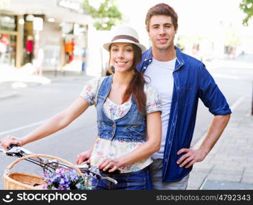 Happy couple in city with bike. Happy young couple in city with bike