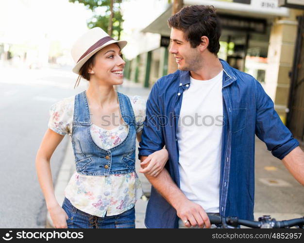 Happy couple in city with bike. Happy young couple in city with bike