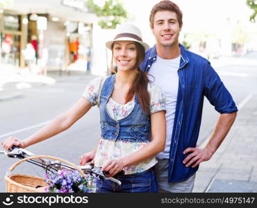 Happy couple in city with bike. Happy young couple in city with bike