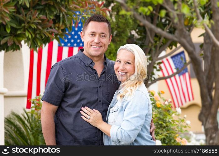 Happy Couple In Front of Houses with American Flags.