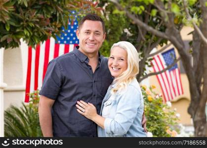 Happy Couple In Front of Houses with American Flags.
