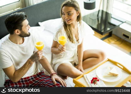 Happy couple in love having romantic breakfast in bed
