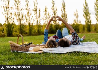 Happy couple in love, lying on the park and enjoying the day together