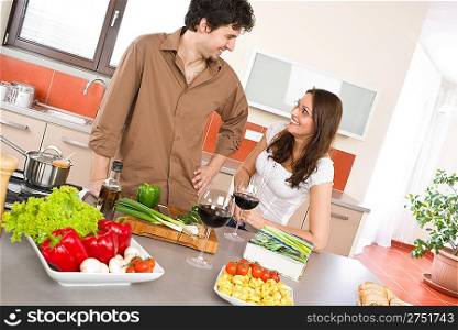 Happy couple in modern kitchen with red wine cook together