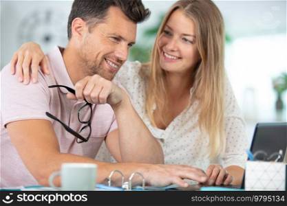 happy couple in new flat using laptop