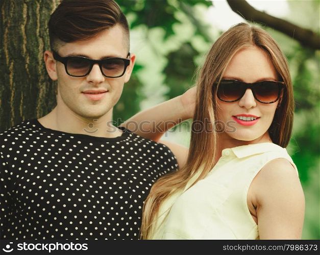 Happy couple in park. Love and happiness. Young happy couple lovers wearing sunglasses dating in summer park outdoor.