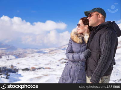 Happy couple in snowing mountains, active lifestyle, winter vacation, luxury wintertime resort, loving family, cold weather