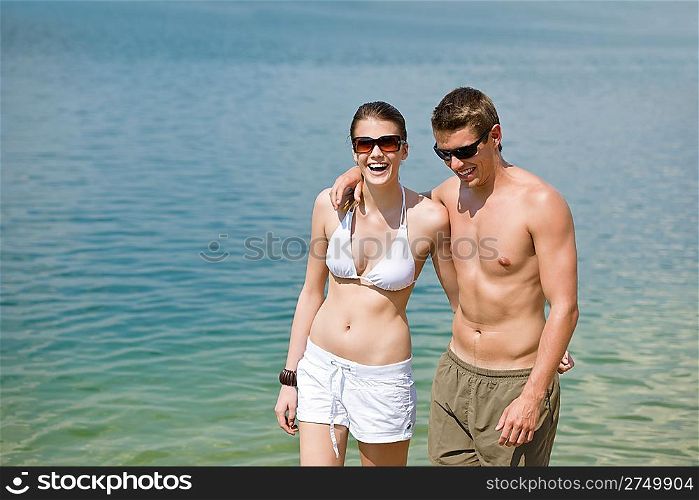 Happy couple in swimwear at sea enjoy summer sun