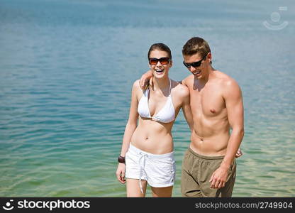 Happy couple in swimwear at sea enjoy summer sun