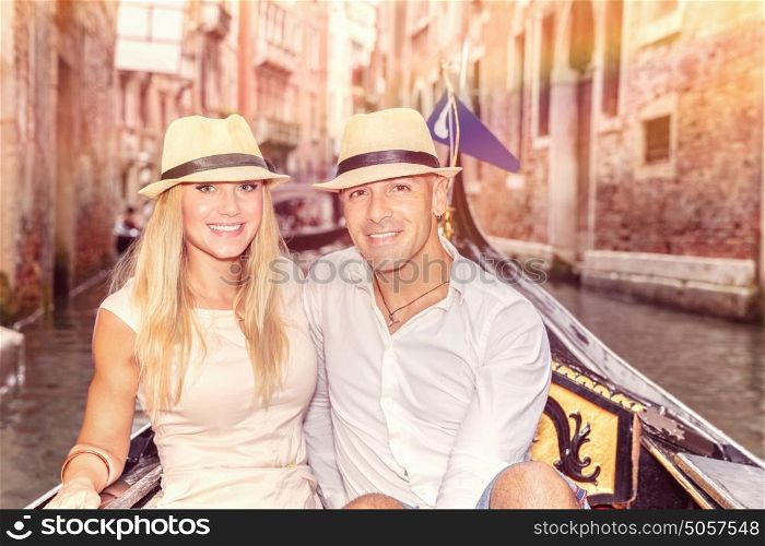 Happy couple in Venice, beautiful young people riding on the gondola along river on narrow street, romantic honeymoon in Italy, Europe