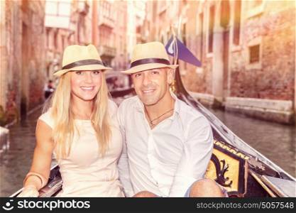 Happy couple in Venice, beautiful young people riding on the gondola along river on narrow street, romantic honeymoon in Italy, Europe