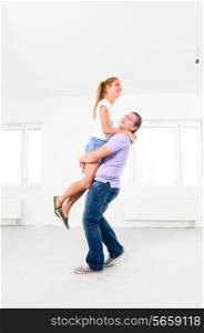 happy couple is jumping at their new empty apartment