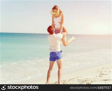 Happy couple jumping on beach vacations. Travel concept of young couple cheering for summer holidays on beach