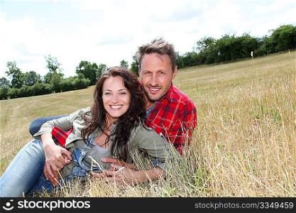 Happy couple laying down meadow