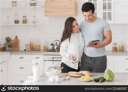 happy couple learning how cook from online recipes