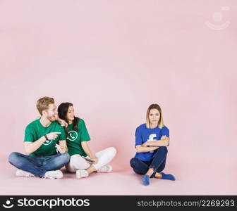 happy couple looking sad woman pink background