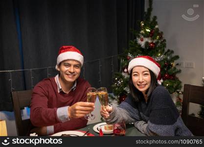 happy couple lovely man and woman smile and celebrating together at christmas day night in dining room that decorated with christmas tree for christmas festival day