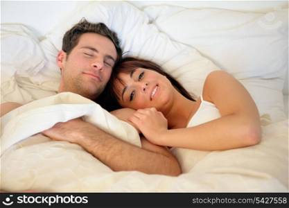 Happy couple lying in bed