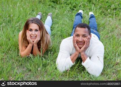 Happy couple lying on the grass in the field thinking about his future
