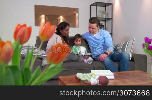 Happy couple, married people, young man and woman with daughter, multiethnic marriage relationship, husband and wife. Mother and father reading book to child, mom and dad with baby