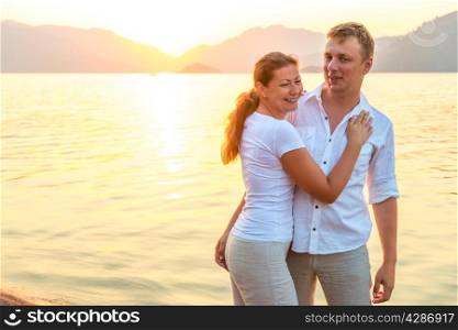 happy couple near the sea at sunrise