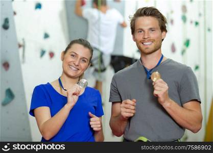 happy couple of alpinists holding a medal