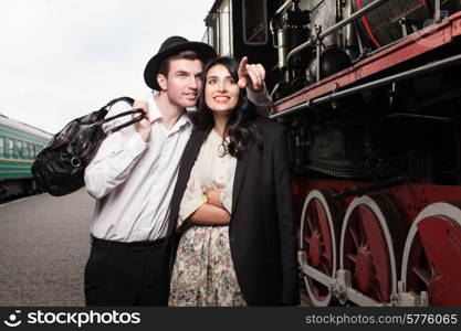 happy couple of traveler at railway station