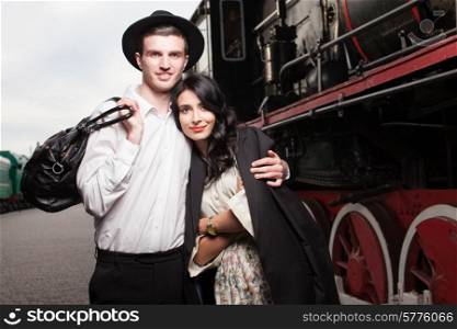 happy couple of traveler at railway station