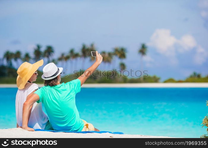 Happy couple on the beach vacation. Young couple on white beach during summer vacation.