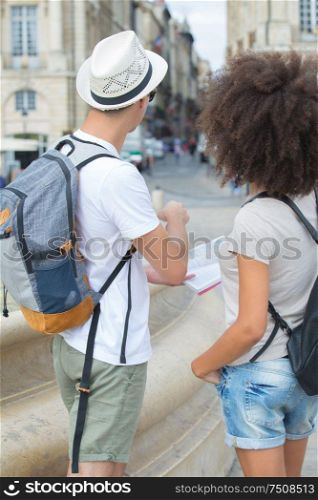 happy couple on vacation sightseeing city with map